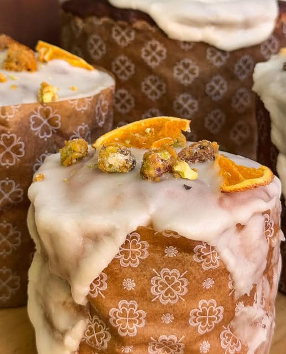 Budín de Demente con glaseado blanco, naranja confitada y pistachos